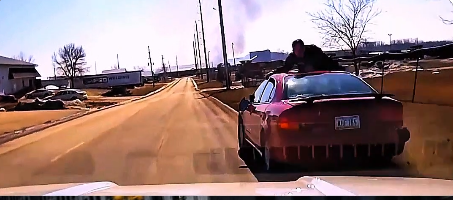 driver fleeing with cop on hood