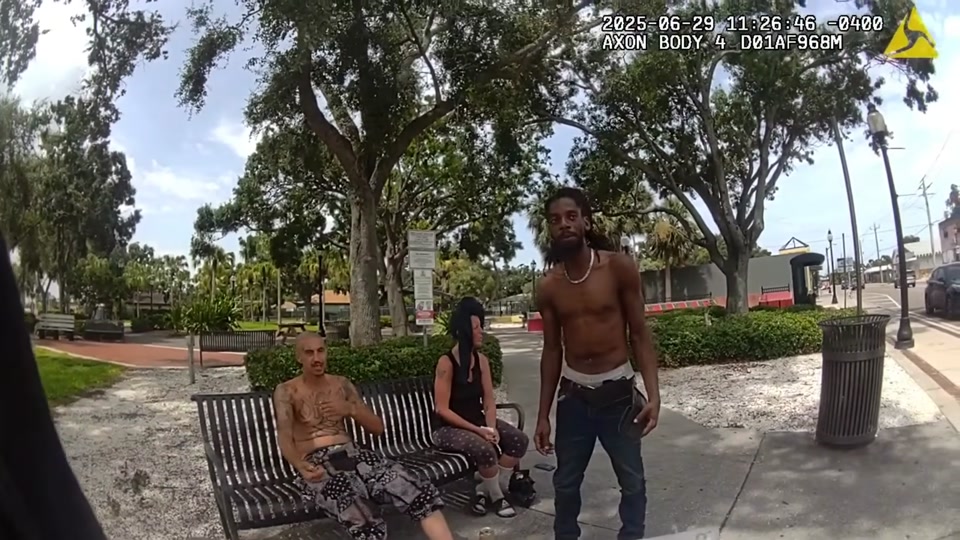 Man standing near a park bench during police encounter