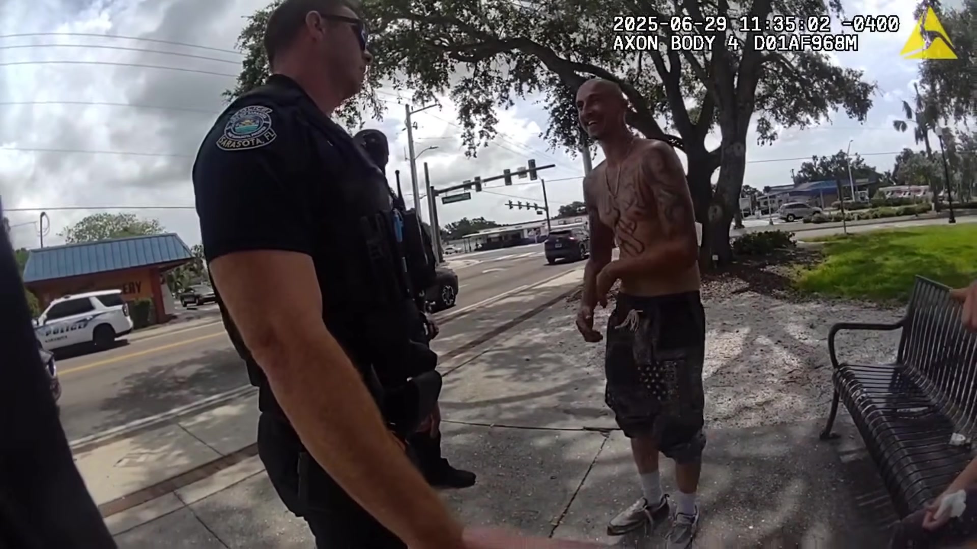 Additional officer speaking with the man beside the park