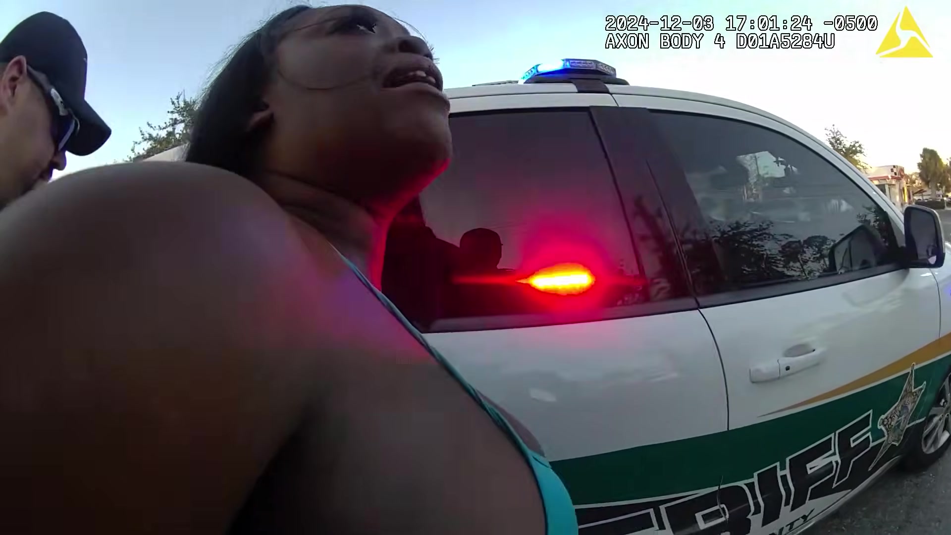 Thumbnail showing woman being arrested beside Flagler County Sheriff's vehicle