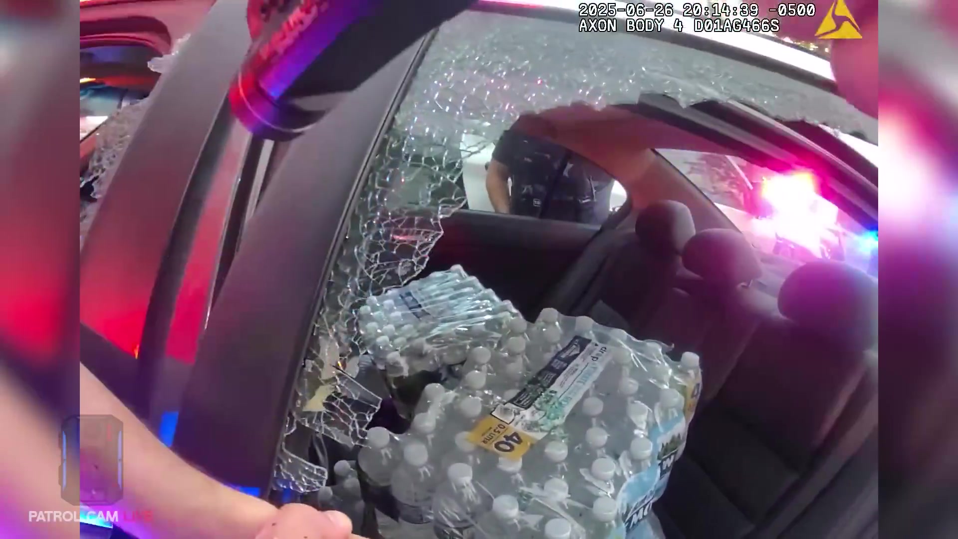 Real frame from the supplied body-camera video showing the damaged driver-side window during the confrontation
