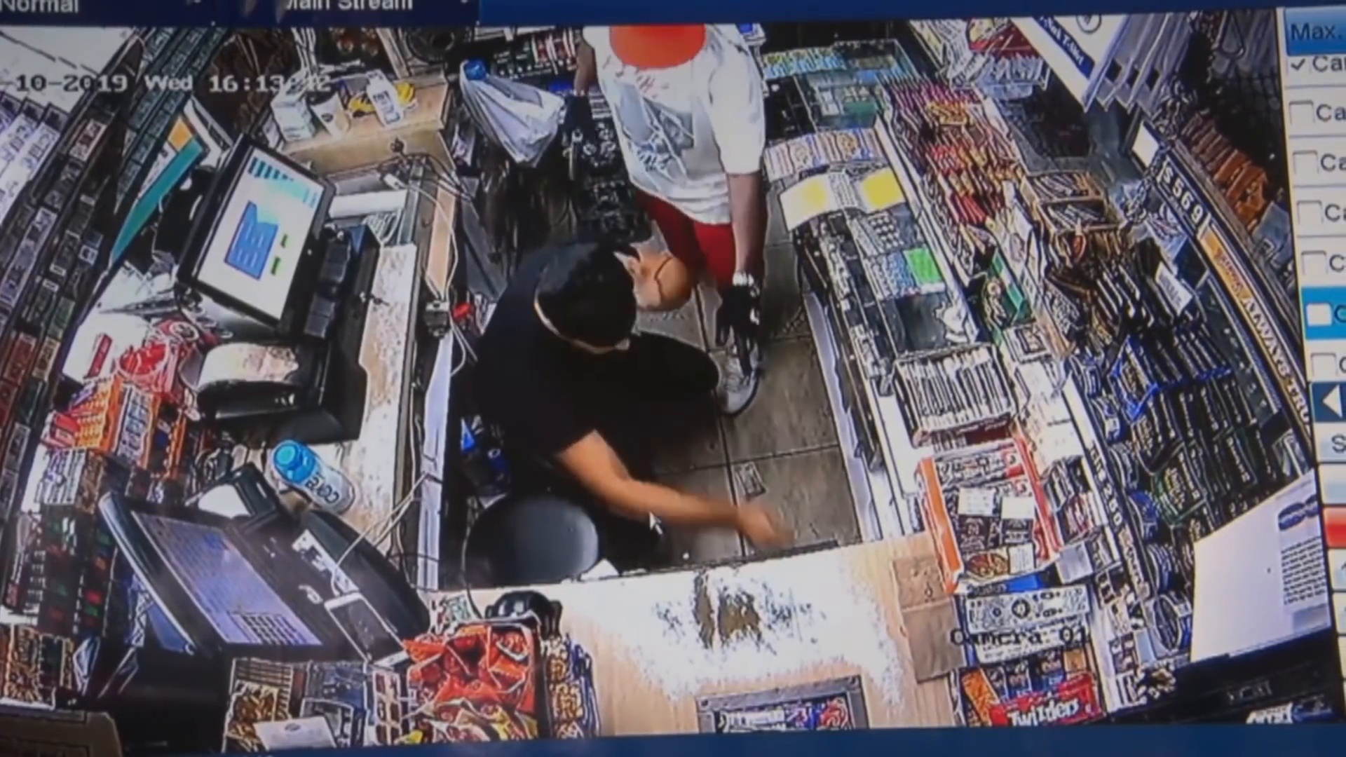 Real surveillance frame from the supplied footage showing the armed robbery behind the Valero counter