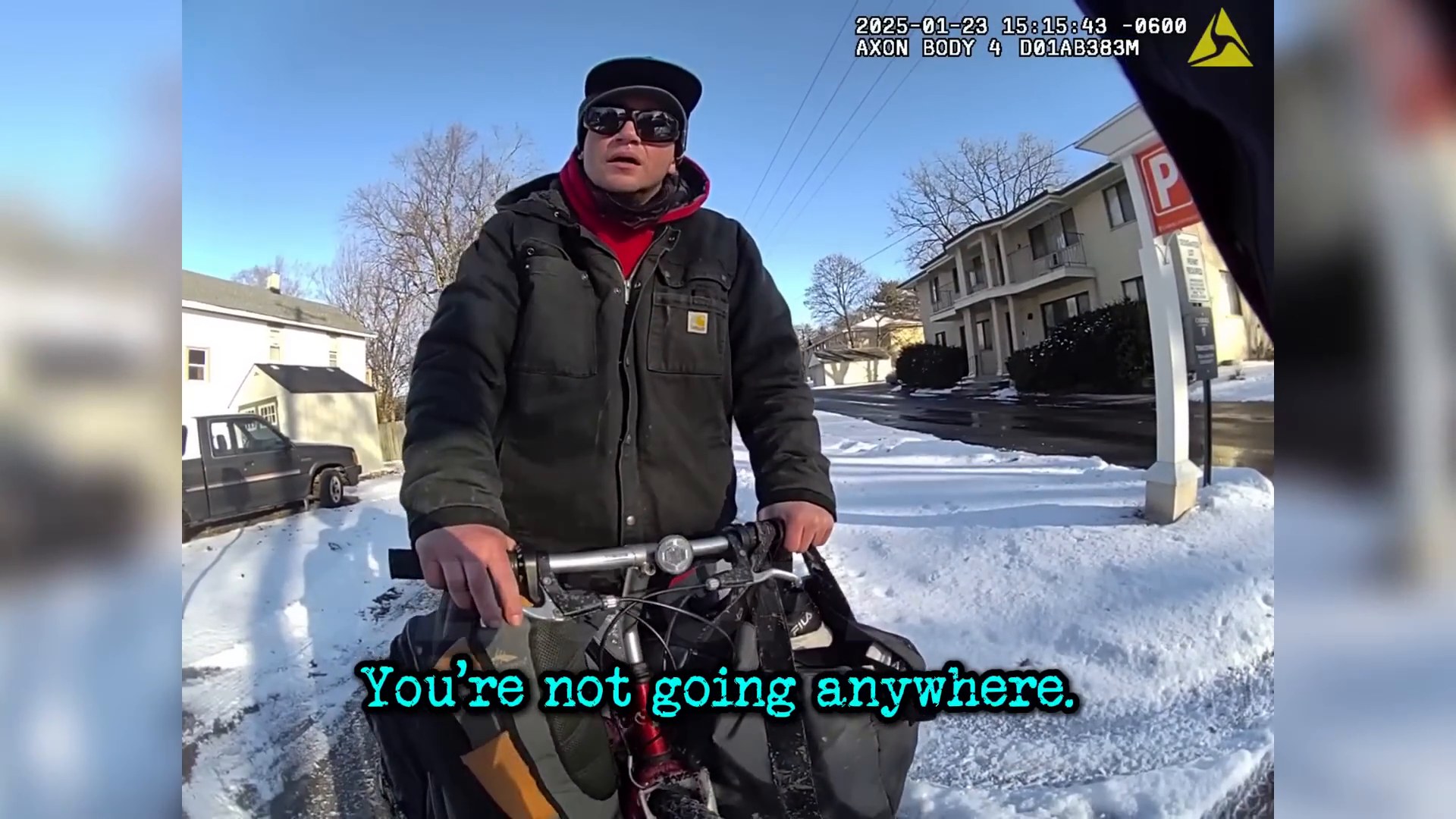 Uncropped frame from the supplied body-worn-camera footage showing the man with his bicycle on a snowy street