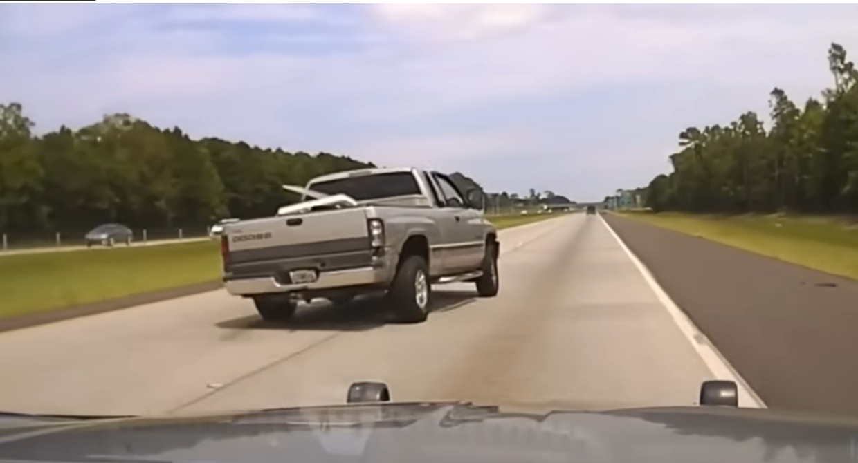 Real frame from the July 5, 2021 dash-camera footage showing the Dodge pickup angled across the highway during the pursuit