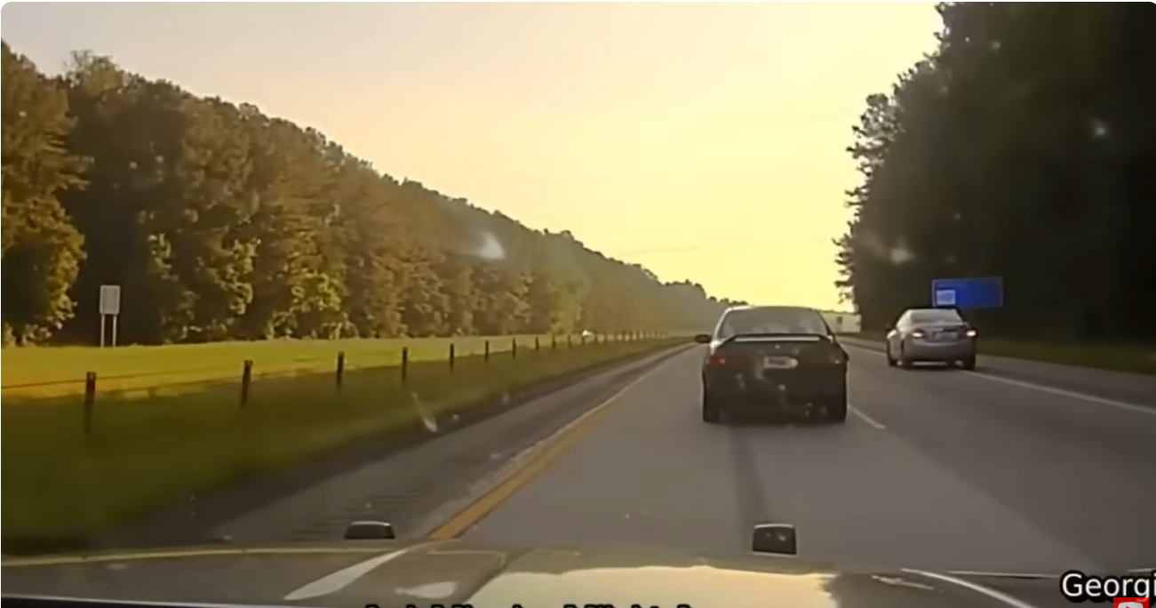 Real frame from the supplied Georgia pursuit footage showing the black coupe ahead of the patrol vehicle