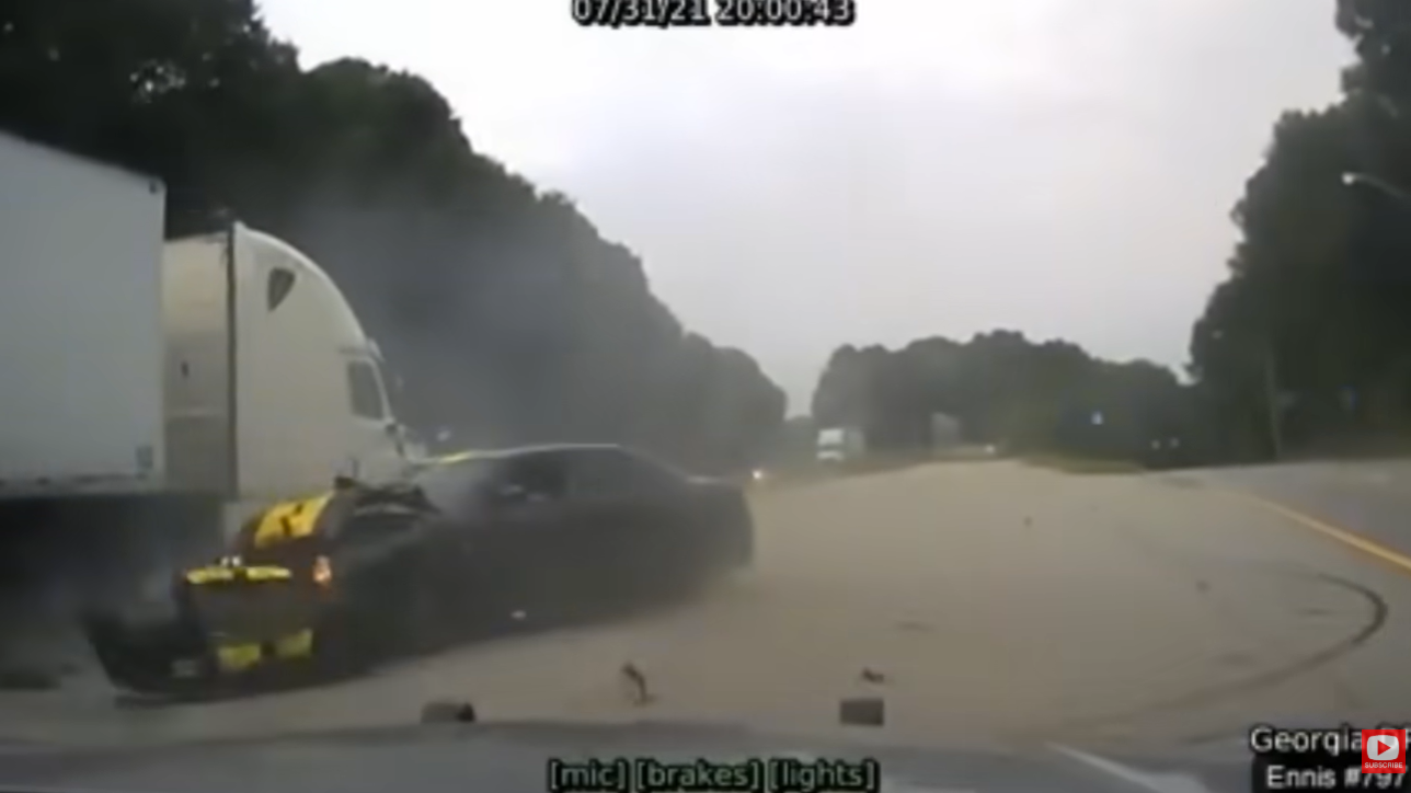 Georgia DPS dash-camera frame showing the striped vehicle colliding near a tractor-trailer at the end of the pursuit