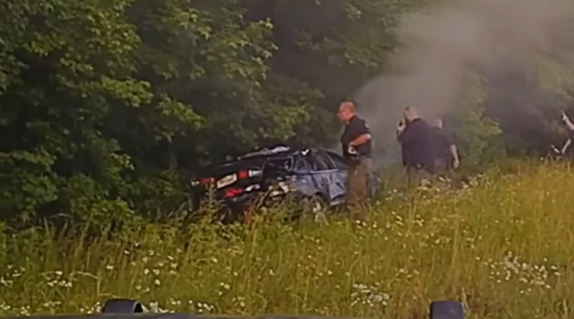 Real frame showing officers beside the heavily damaged black coupe after the Georgia pursuit