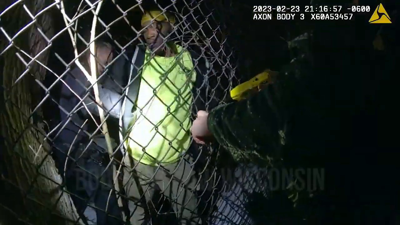 Real body-camera frame showing officers at the fence during the final phase of the Deandre Patterson arrest